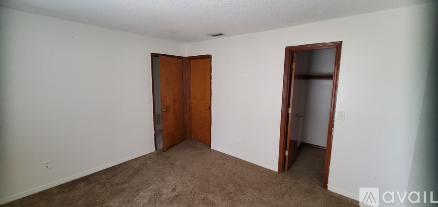 A room with two doors and a carpeted floor.