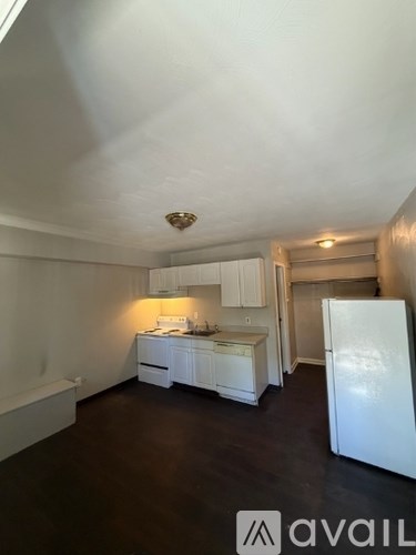 A kitchen with white appliances and cabinets.