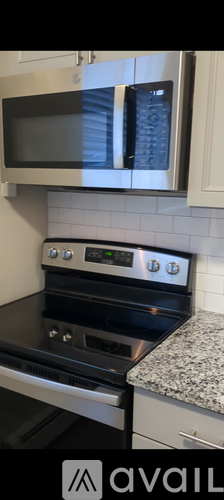 A black oven with a digital display and a microwave above it.