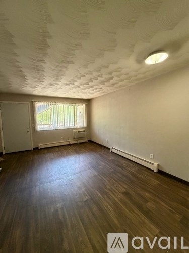 A room with wooden floors and a ceiling with a unique design.