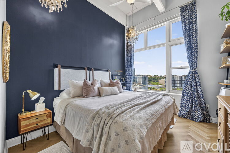 A bedroom with a large bed and a chandelier.