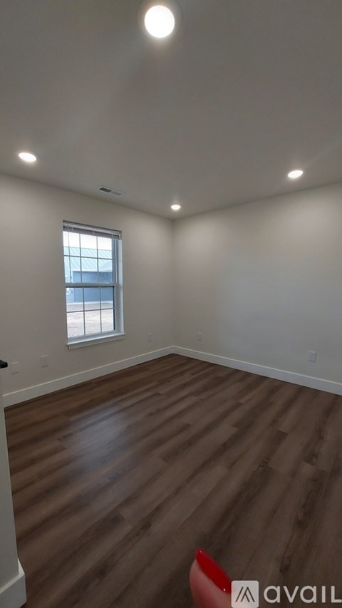 A room with wooden flooring and a window.
