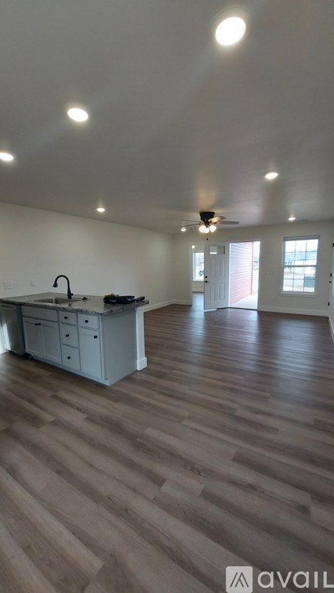 A kitchen with a wooden floor and a ceiling fan.