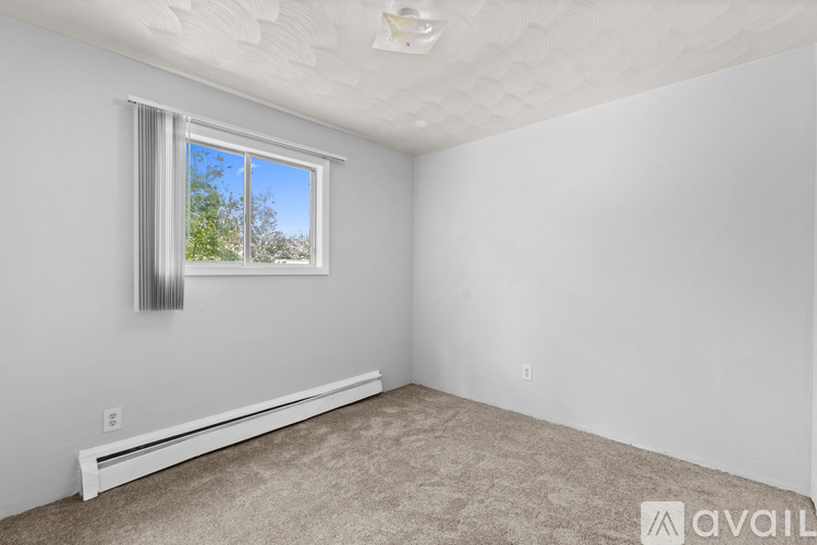 A bedroom with a bed, nightstand, and a television.