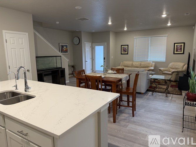 A kitchen with a white countertop and a dining table with chairs.