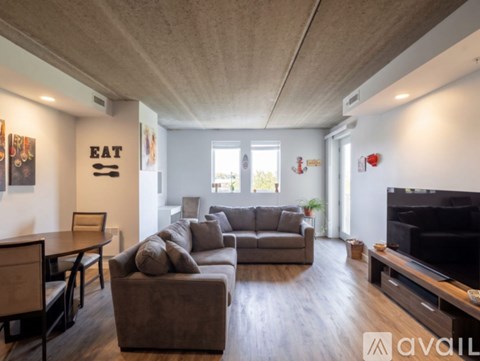 A living room with a grey couch and a black television.