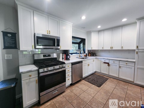 A kitchen with white cabinets and a black stove top.
