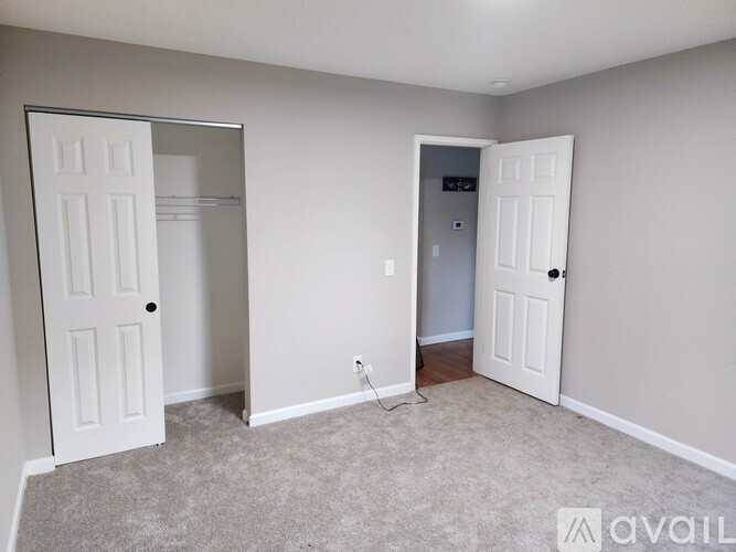 A room with two white doors and a carpeted floor.