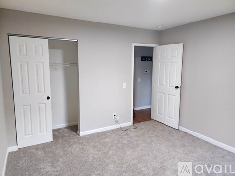 A room with two white doors and a carpeted floor.