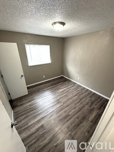 A room with wooden flooring and a window.