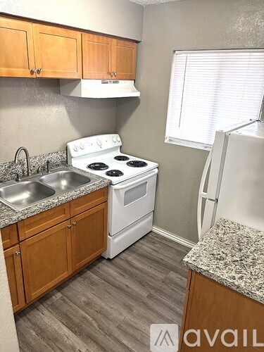 A kitchen with a white stove top oven and a white refrigerator.