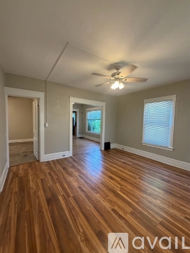 A room with wooden floors and a ceiling fan.
