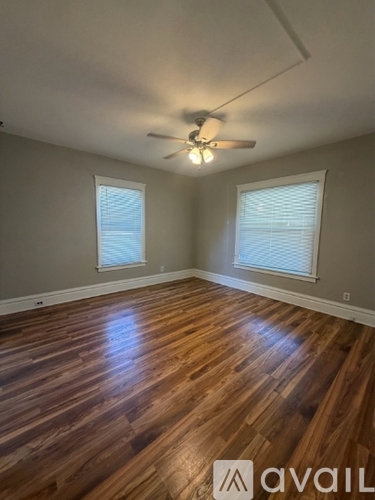 A room with wooden flooring and a ceiling fan.