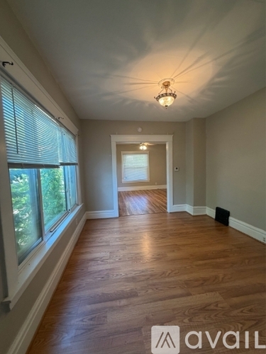 A long hallway with wood floors and a light on the ceiling.