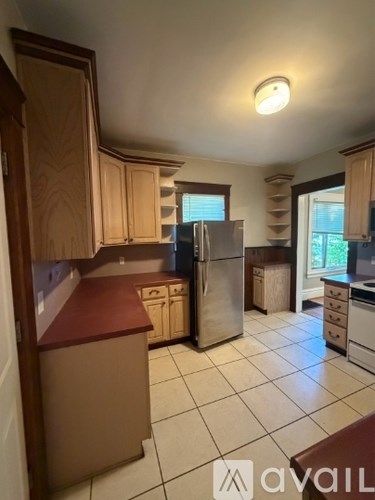 A kitchen with wooden cabinets and a refrigerator.