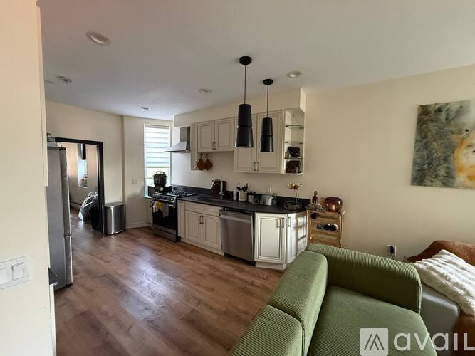 A kitchen with a green couch in front of it.