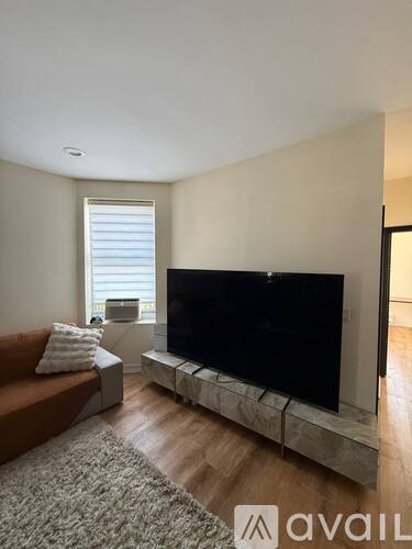 A living room with a large television and a couch.
