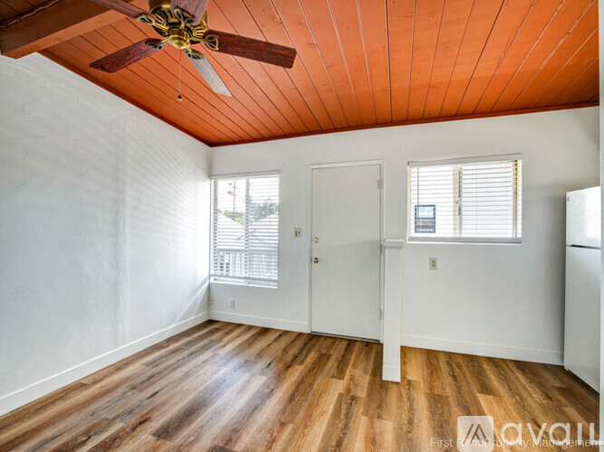 A room with a wooden floor and a ceiling fan.