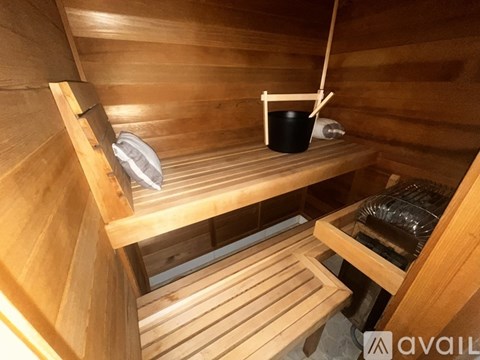 A wooden sauna with a bucket and a towel.