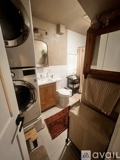 A small kitchen with a stove top oven and a toilet.