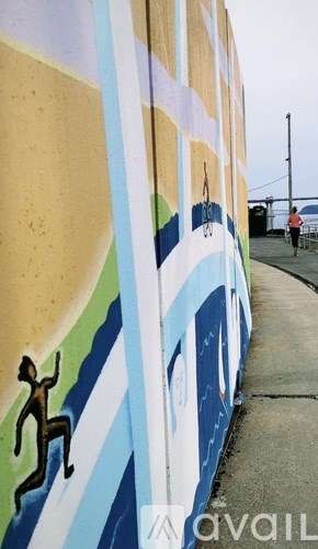 A mural of a person climbing a wall is painted on a building.