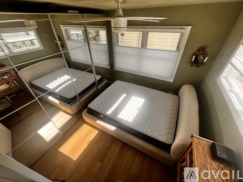 A bedroom with two beds and a ceiling fan.