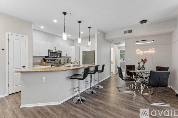 A well-lit kitchen with a bar area and a dining table set up.