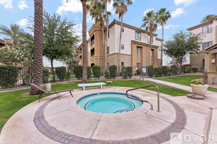 A pool surrounded by a concrete patio and a fence with a bench.