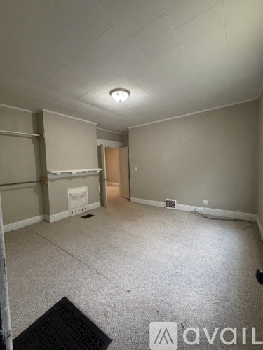 A room with a carpeted floor and a ceiling light.