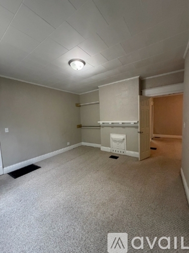 A room with a carpeted floor and a ceiling light.