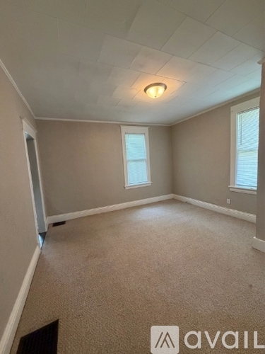 A room with a carpeted floor and a window.