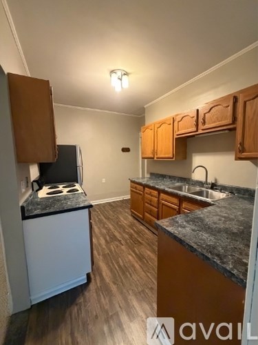 A kitchen with wooden cabinets and a black stove top oven.