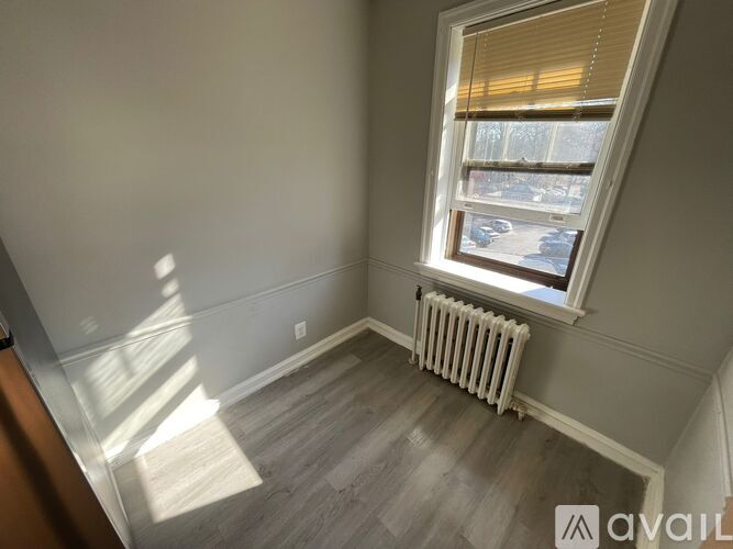 A room with a window and a radiator on the floor.