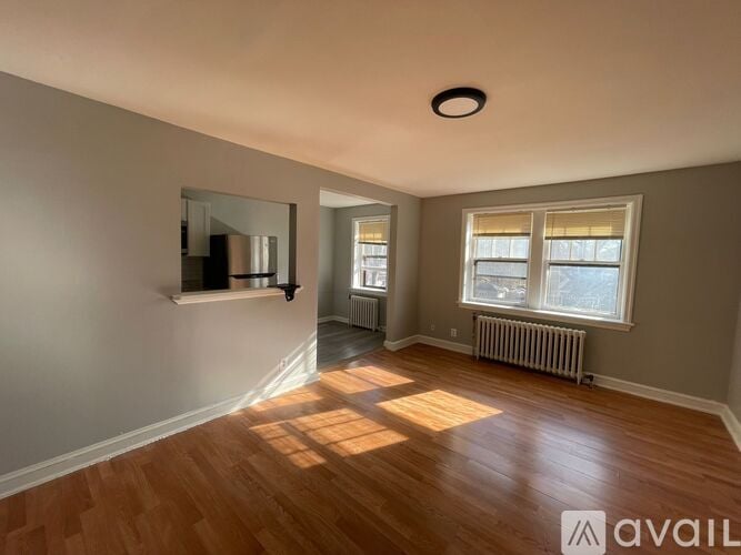 A room with wooden floors and a window with blinds.
