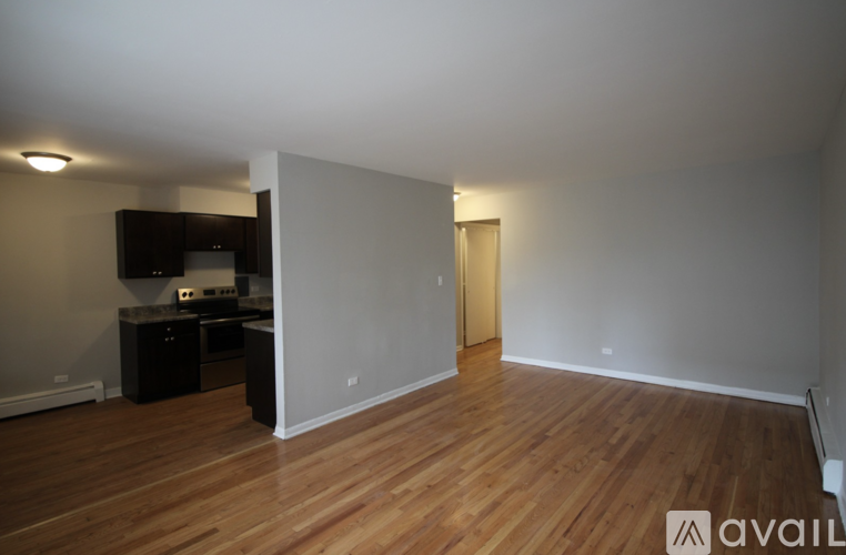 A room with wooden floors and a wall-mounted TV.