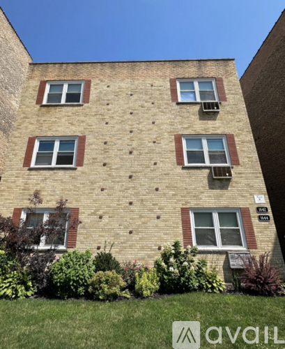 A brick building with a green lawn in front.