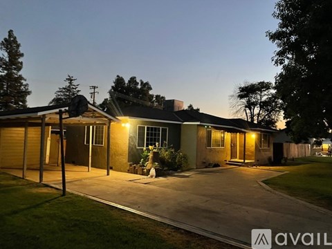 A house with a driveway and a garage is lit up at dusk.