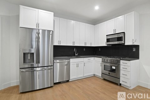 A kitchen with white cabinets and stainless steel appliances.