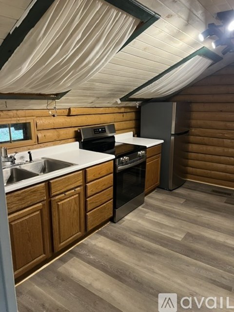 A kitchen with wooden cabinets and a black stove top oven.