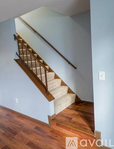 A wooden staircase with a white wall on the side.