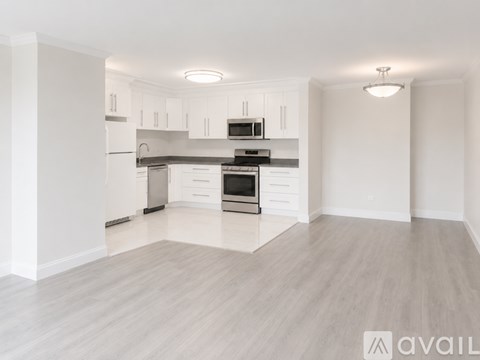 A spacious kitchen with white cabinets and stainless steel appliances.