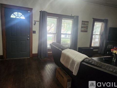 A living room with a dark door and a black couch.