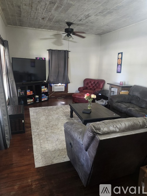 A living room with a grey couch and a red chair.