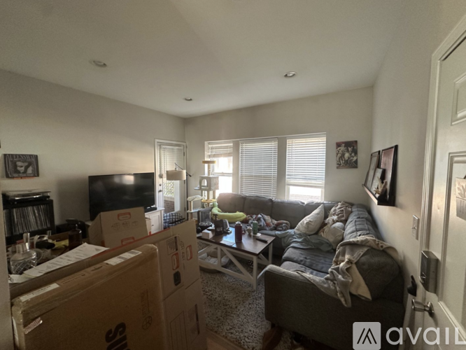 A living room with a couch, a coffee table, and a television.