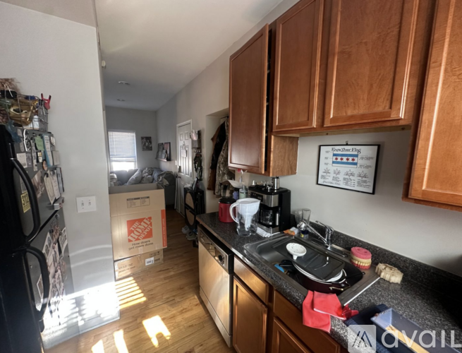 A kitchen with wooden cabinets and a black countertop.