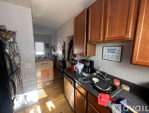 A kitchen with wooden cabinets and a black countertop.