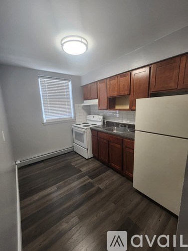 A kitchen with wooden cabinets and a white fridge.