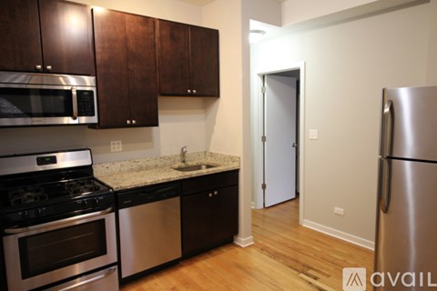 A kitchen with dark brown cabinets and stainless steel appliances.