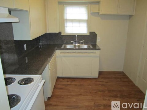 A kitchen with white cabinets and a black countertop.