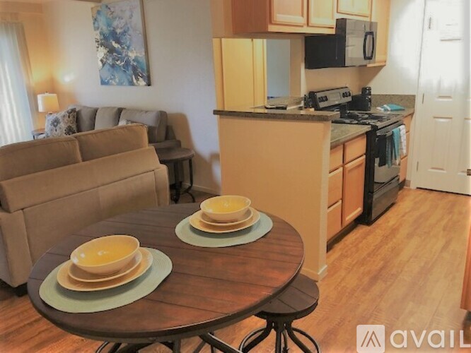 A kitchen with a table set for two in the middle of the room.